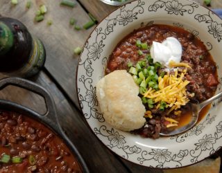 bowl of black bean chili with bread and toppings