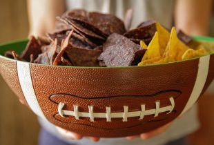 a football shaped bowl full of tortilla chips