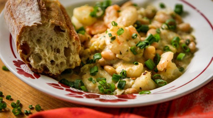 a close up of a plate of cafe reconcile white beans and shrimp