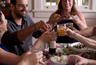 a family toasting at a dinner table