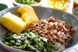 a plate of blackeye peas and a side of collard greens and corn bread