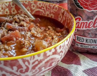 bowl of chili with can of seasoning and bag of beans