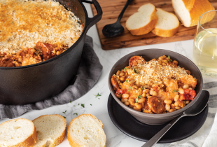 a bowl of Camellia's Shrimp, Andouille and White Bean Cassoulet next to a dutch oven