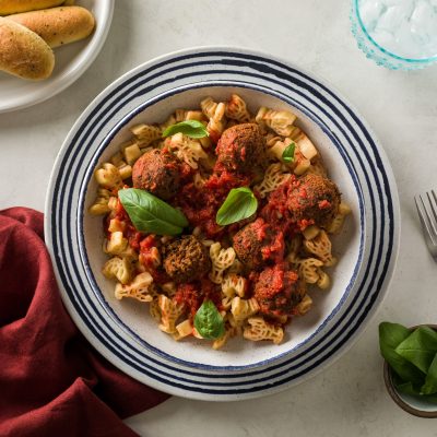a bowl of kid friendly vegan meatballs and pasta that is crawfish shaped