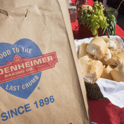 close up of a brown plastic bag from leidenheimer with its logo on it next to a basket of french bread