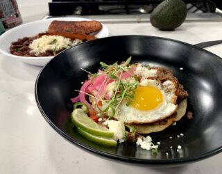 a close up of pico de gallo on a dish of red bean huuvos rancheros wwith a side of red beans and rice with sausage