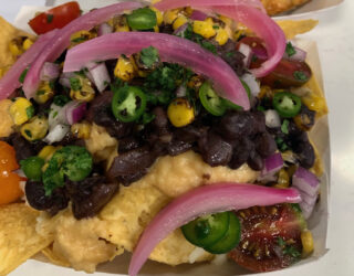close up image of jerk black beans on top of plate of nachos