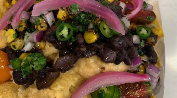 close up image of jerk black beans on top of plate of nachos