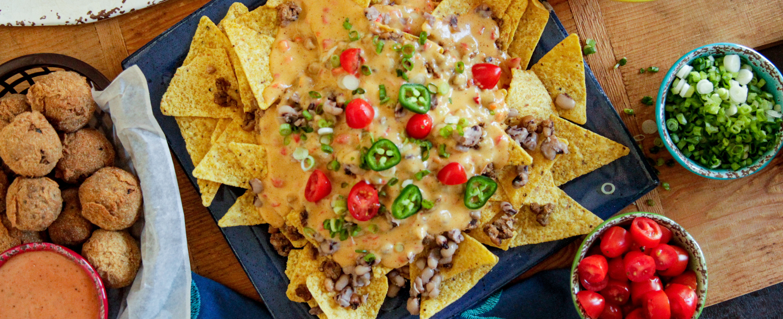 A spread of nachos, chips, and assorted dishes arranged on a table, inviting for a casual meal or gathering.